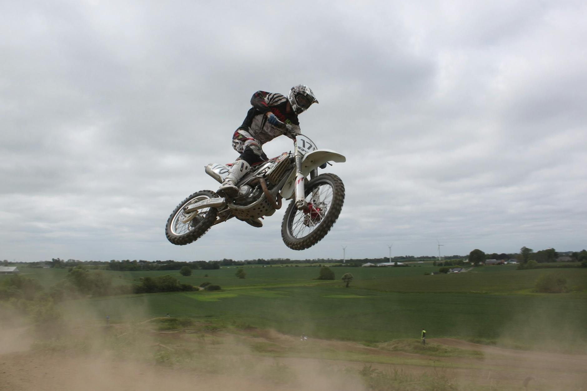 Man Riding Moto Cross Bike Macht Tricks In Der Luft Unter Bew&ouml;lktem Himmel W&auml;hrend Des Tages